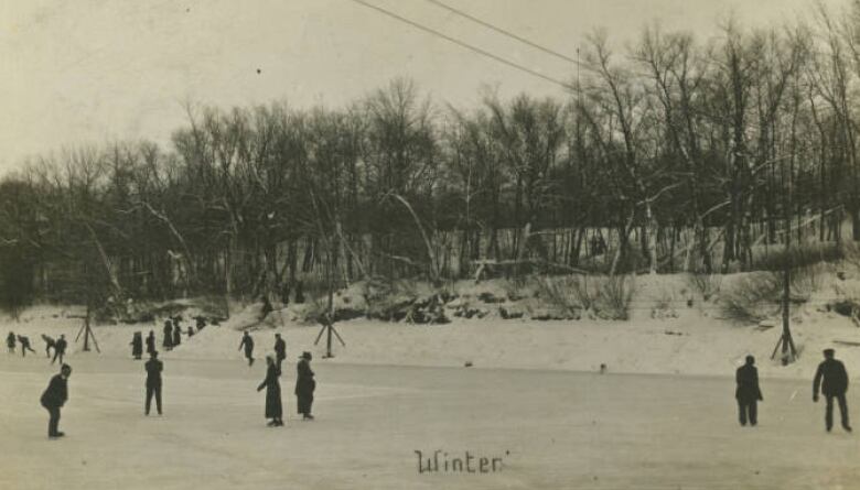 Black and white photo of people skating on a river