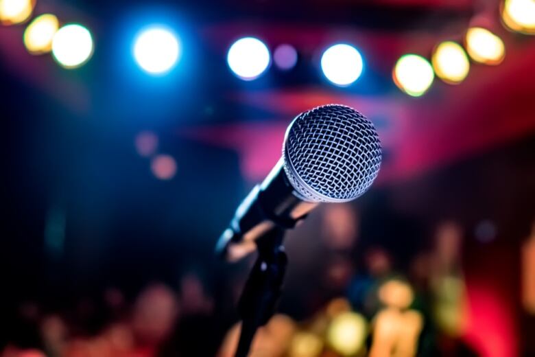 Microphone with blurry lights and audience in background