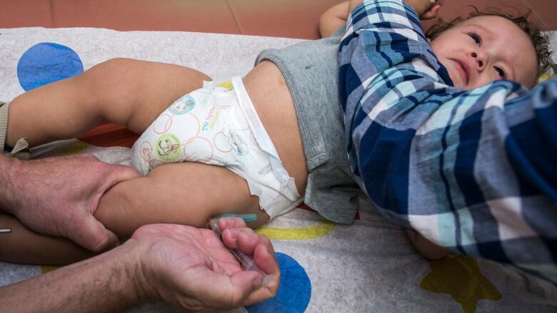 A toddler being vaccinated.