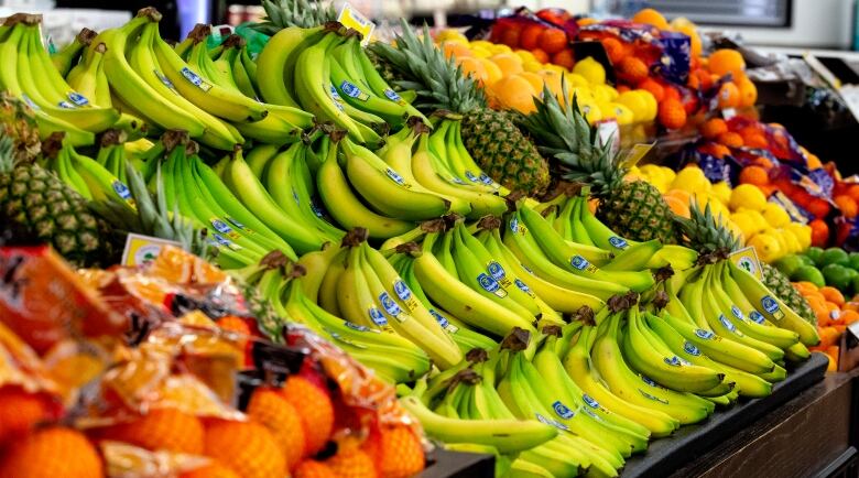 Produce including fruits and vegetables on display at grocery store.