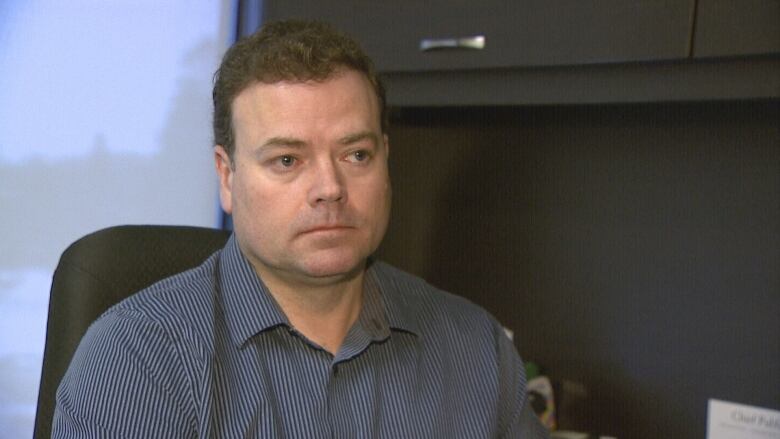 P.E.I.'s manager of environmental health Ryan Neale seated at his desk.