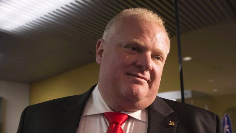 A man wears a suit and a red tie.