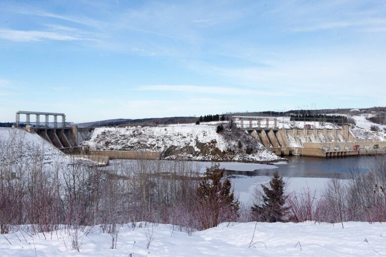 A dam sits at the head of a body of water in winter.