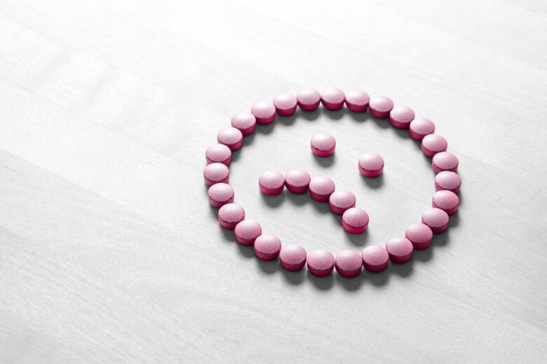 Pills arranged in a sad face.