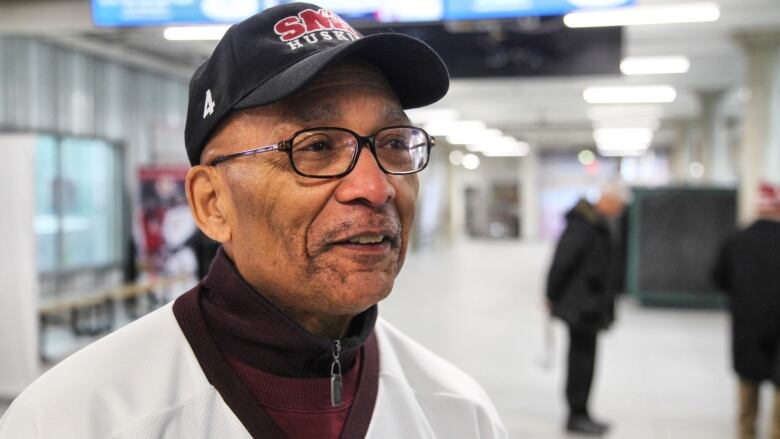 Man looks to the side of the camera, with a partial smile on his face.