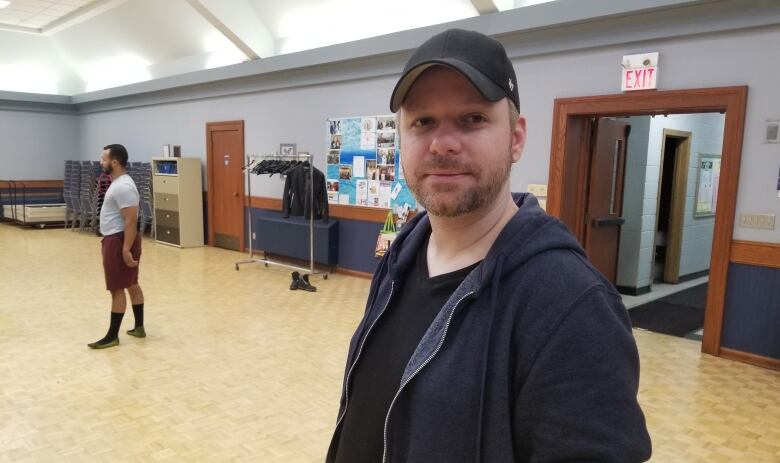 A man with a beard in a black cap. 