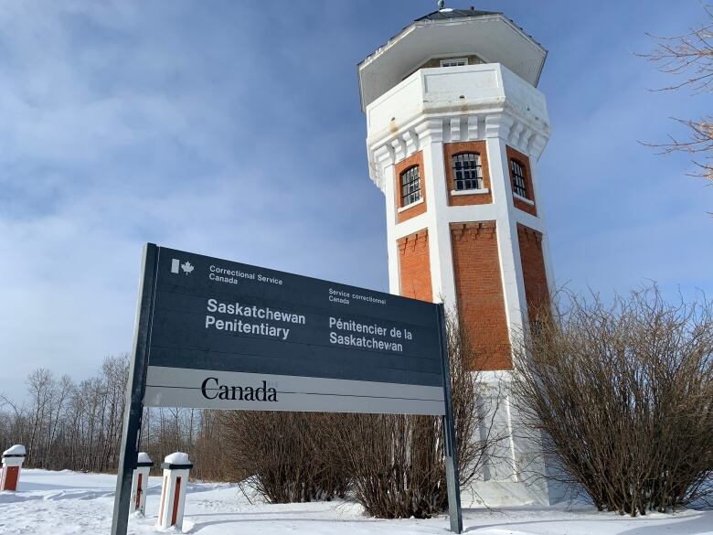 large building with sign in front of that holds prisoners.