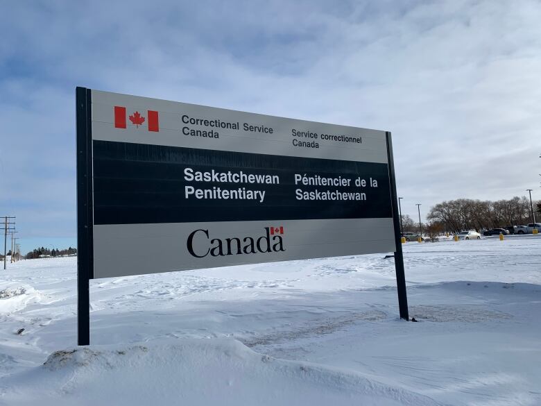 A sign stands on snowy ground. It says 