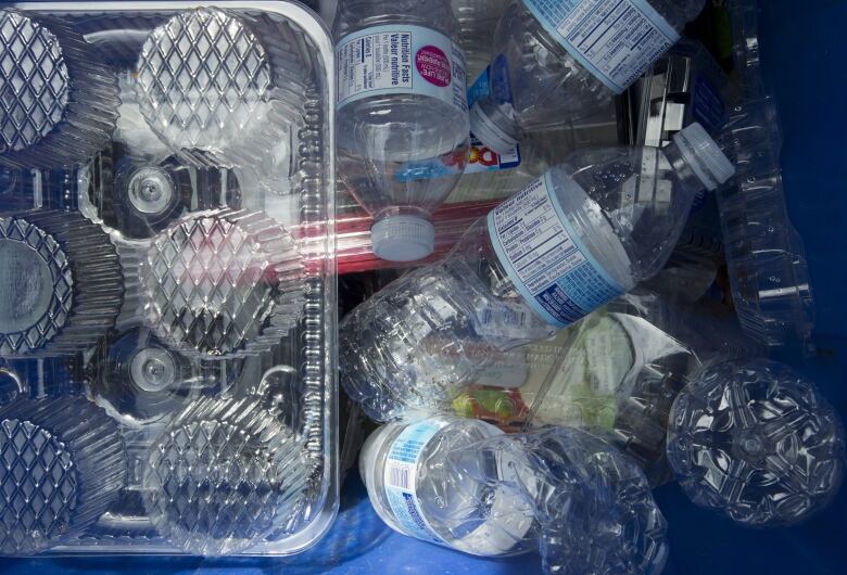 plastic containers lie on the ground piled up.