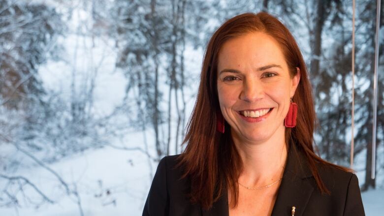 Head shot against snowy forest background.