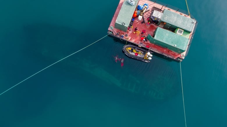 Qiniqtiryuaq (barge) above the Erebus site, wreck and divers visible.