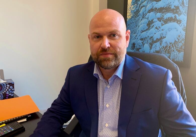 A portrait of a man sitting at a desk.