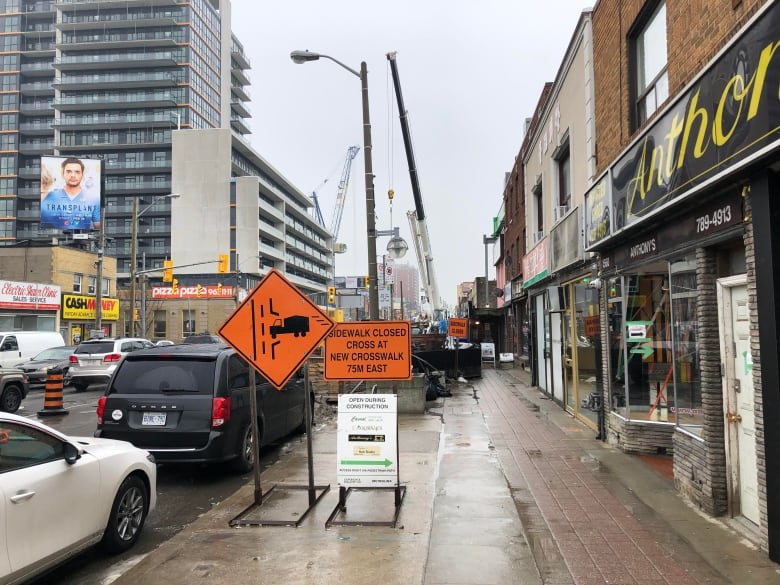 Signage outside Casual Hair Salon indicating a closed sidewalk.