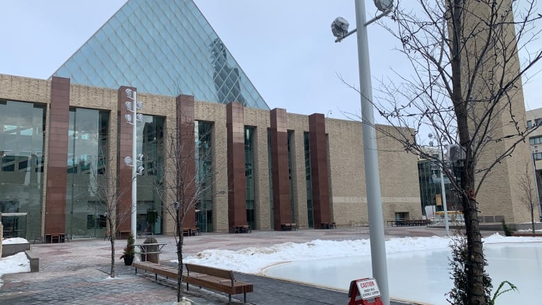 A building with a glass pyramid on top, as seen in winter.