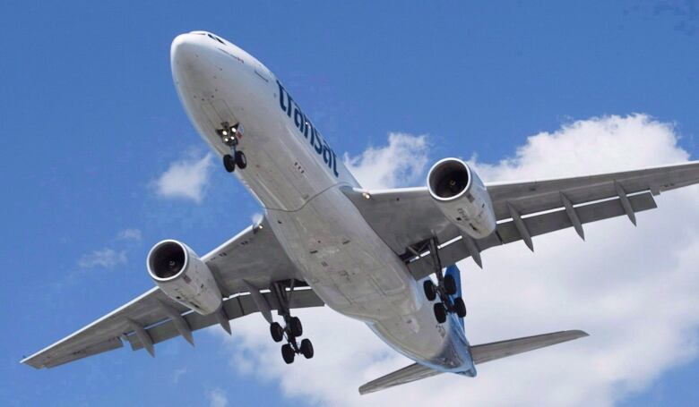 An airplane in flight seen from a low angle.