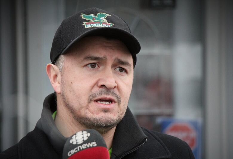 An Indigenous man in a Cape Breton eagles hat