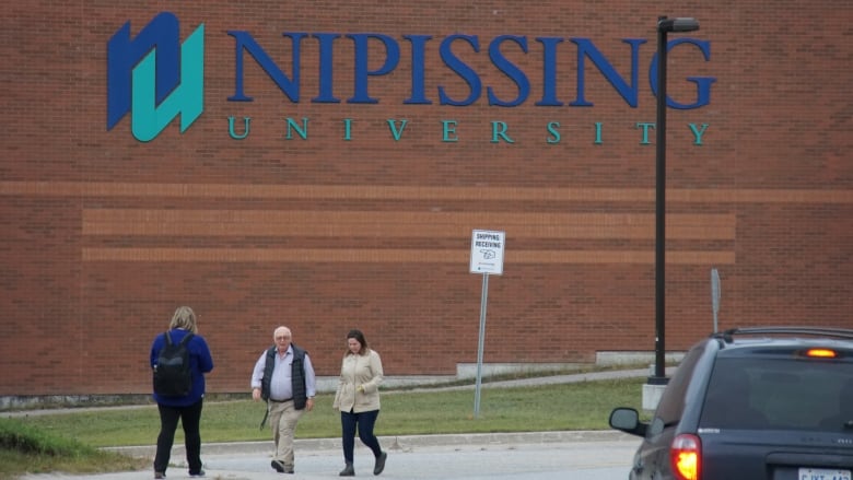 People walking in front of a building.