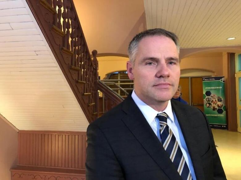 A lawyer poses for a photo in a hallway.