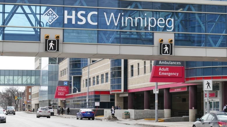 A glass walkway extends from a building and has the writing 