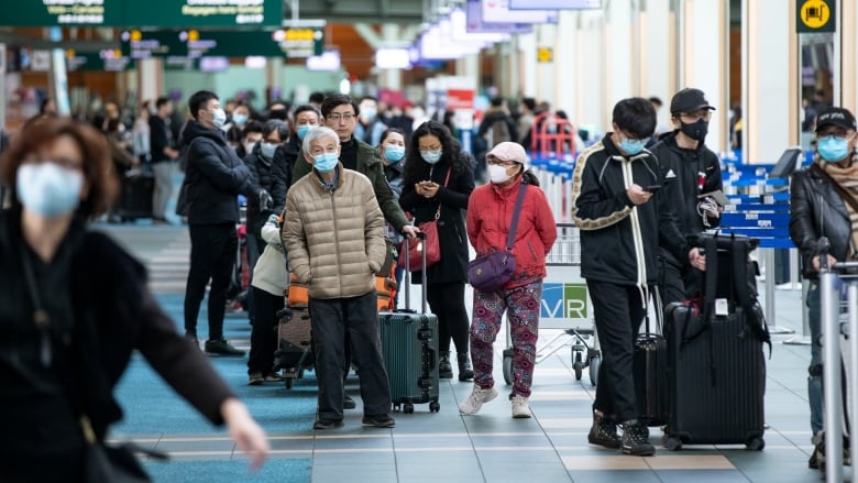 Passengers are pictured at the Vancouver International Airport (YVR) in Richmond, B.C., on March 17, 2020. 