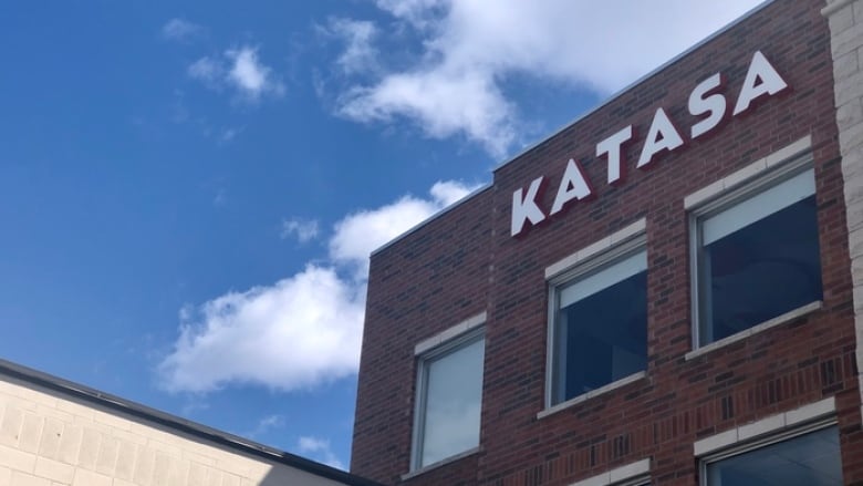 A brick building with a developer's logo on the side.