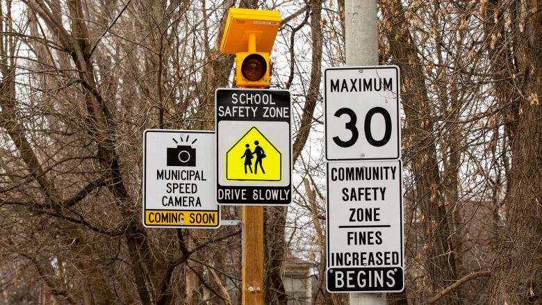 A municipal speed zone sign in Toronto with trees behind it.