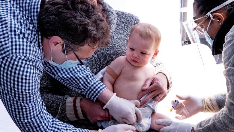 Dr. Daniel Flanders gives baby Penelope her MMR, pneumococcal and meningitis vaccines n Toronto on April 23, 2020 amid COVID-19 precautions. 