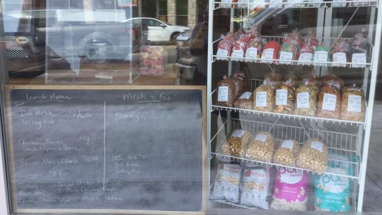 A storefront with a blackboard and some food products.