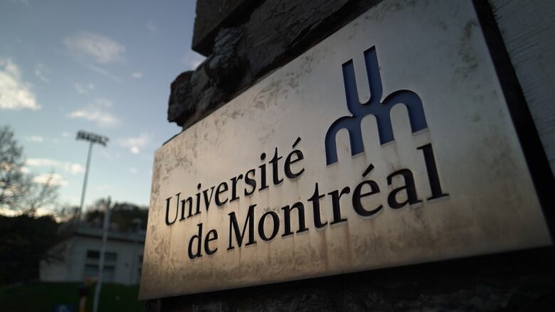 The sign of a university is visible in the evening.