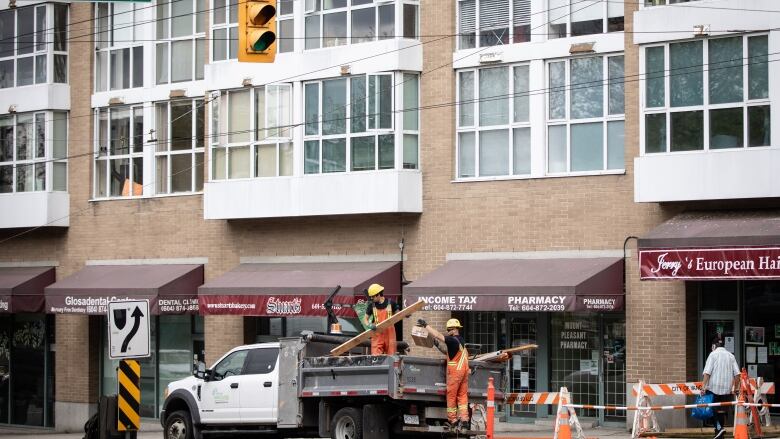 Road work outside of shops and an apartment building in Vancouver on Friday, May 15, 2020.