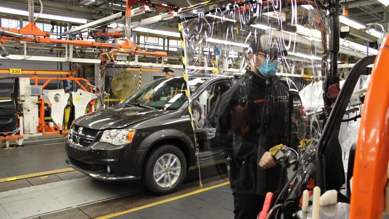 An employee working on the assembly line with added safety precautions at FCA's Windsor Assembly Plant.