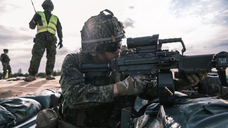 A soldier fires a machine gun.