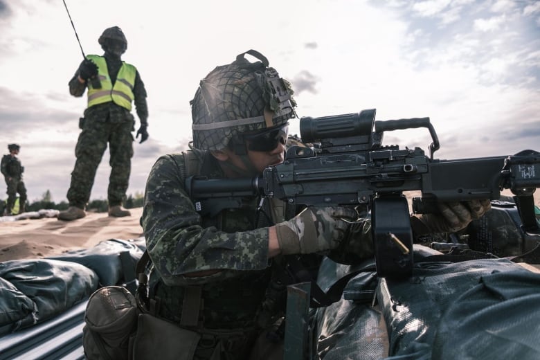 A soldier fires a machine gun.