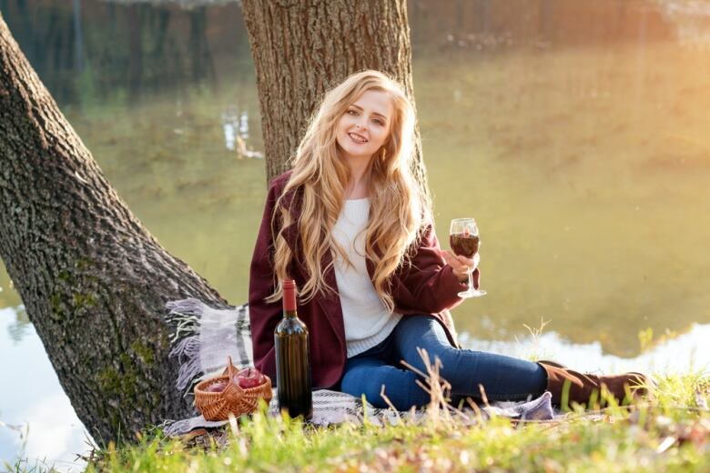 Woman drinking in wine at park.