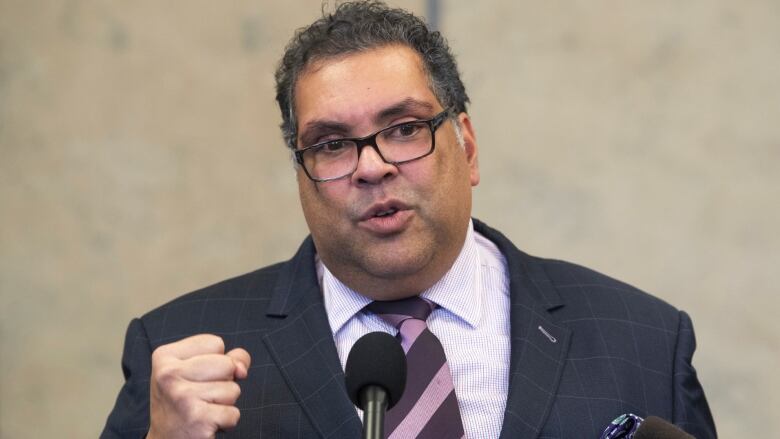 Former mayor Naheed Nenshi speaking at a podium.