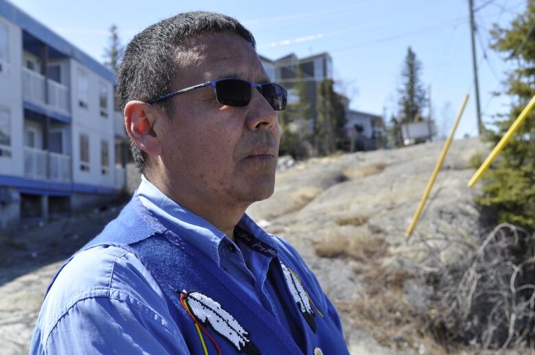 a man wearing sunglasses and beaded vest 