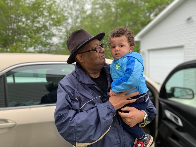 A man holds a child in his arms.