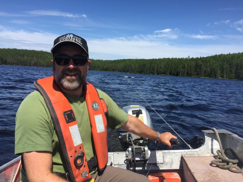 A man sitting and smiling on a boat.