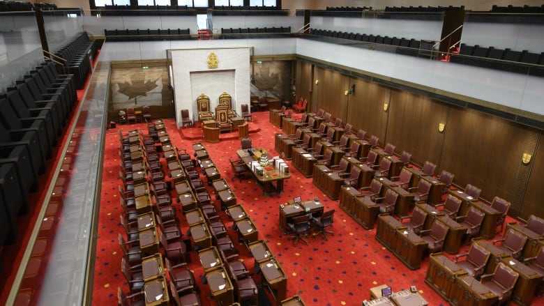 Rows of chairs and desks are shown in Canada's Senate chamber.