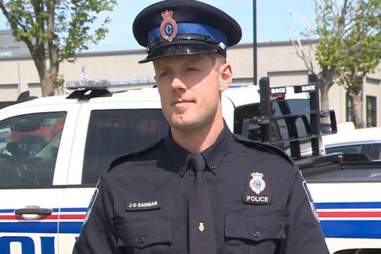 A police officer standing in front of a police truck. 