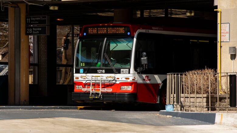 The front of a TTC bus seen coming out of a station.