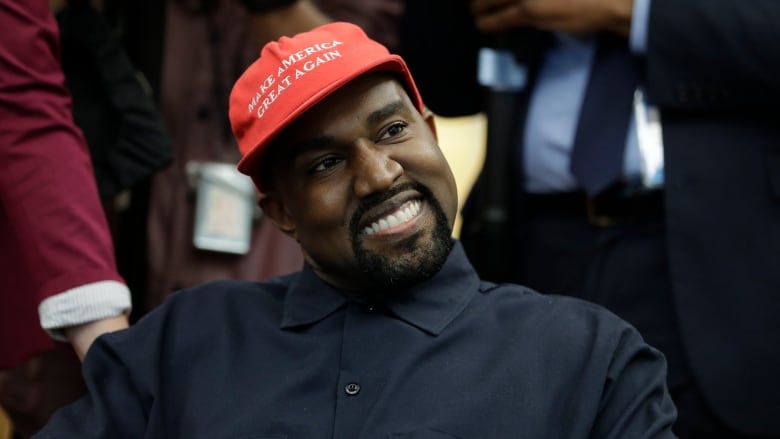 Rapper Kanye West wears a Make America Great again hat during a meeting with President Donald Trump in the Oval Office of the White House on Oct. 11, 2018. West issued a cryptic answer by text to a reporter about his electoral ambitions, but Democrats see Republican influence behind the scenes.