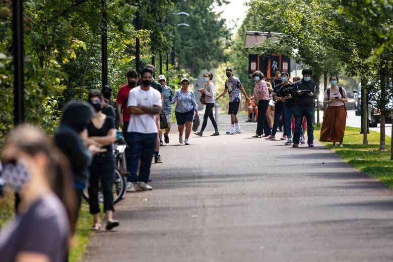 People wait in line at a COVID-19 testing facility is in Burnaby, British Columbia on Wednesday, August 12, 2020. 