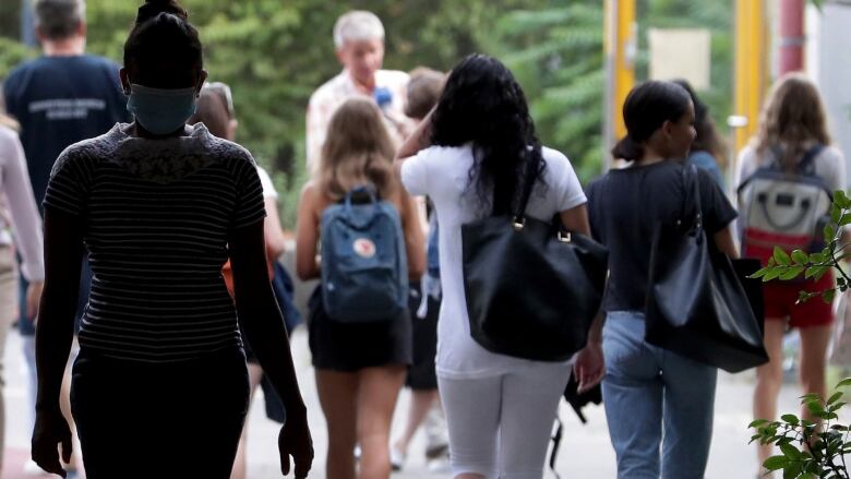 Students with backpacks walking outside.