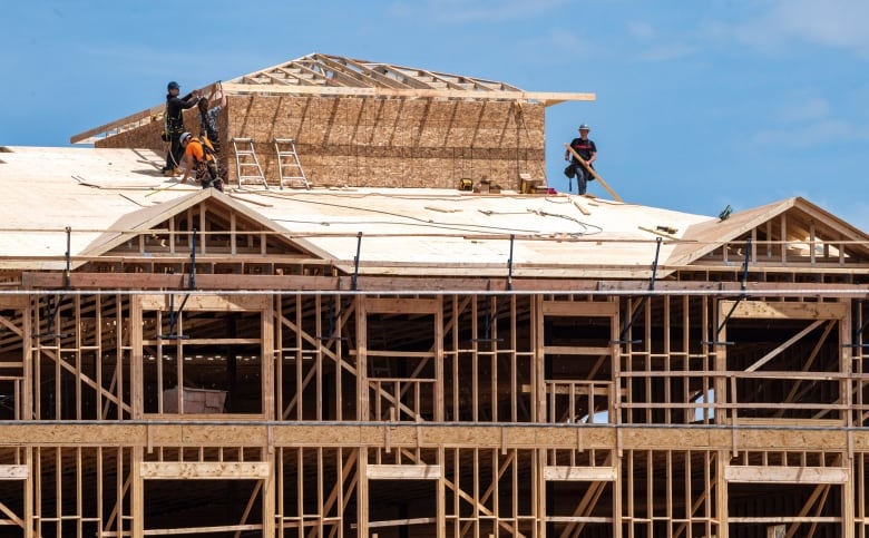 People stand on the roof of a building under construction.