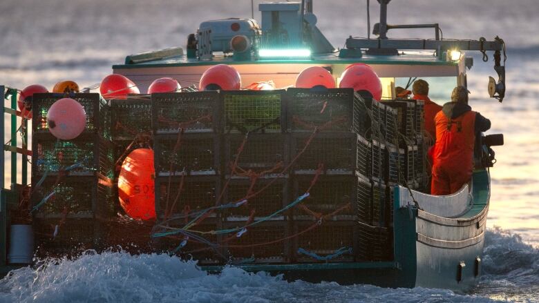 A fishing boat loaded with traps heads through the water.