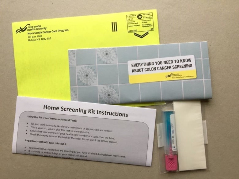 Envelopes and paper and plastic-tubing material with labels describing it as an at-home colon cancer test.