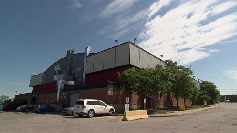 A brick arena building in a parking lot.