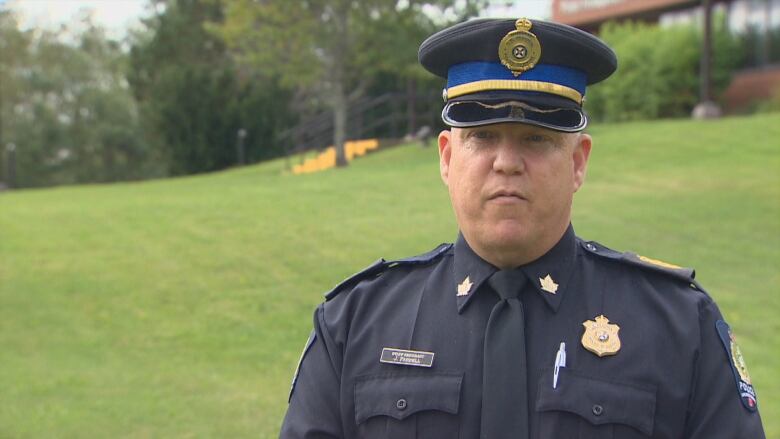 A police officer in a blue uniform and police hat is shown.