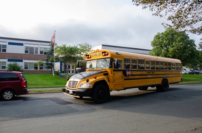 A yellow school bus parked near a school. 